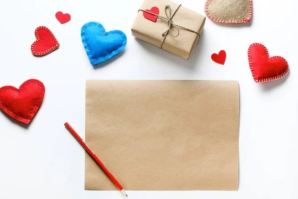 A blank sheet of Craft Paper, a Pencil, a Gift for Valentine\'s Day, Handmade. Red And Blue Hearts Or Valentines On A White Background.