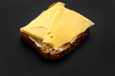 Sandviç peynir ve tereyağı ile siyah ekmek üzerinde