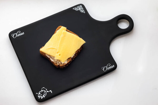Sandwich on black bread with cheese and butter