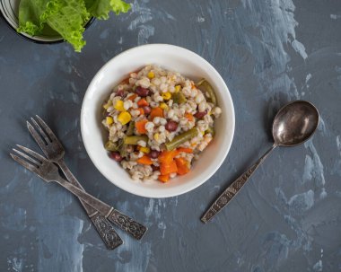 Sebzeli Perlotto ve gri arka planda kızarmış domuz eti.