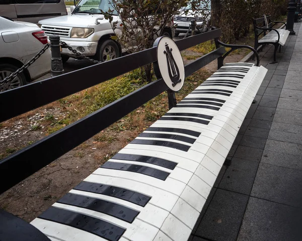 Скамейки в городском пейзаже с оригинальным дизайном, раскрашенные под клавиатуру фортепиано — стоковое фото