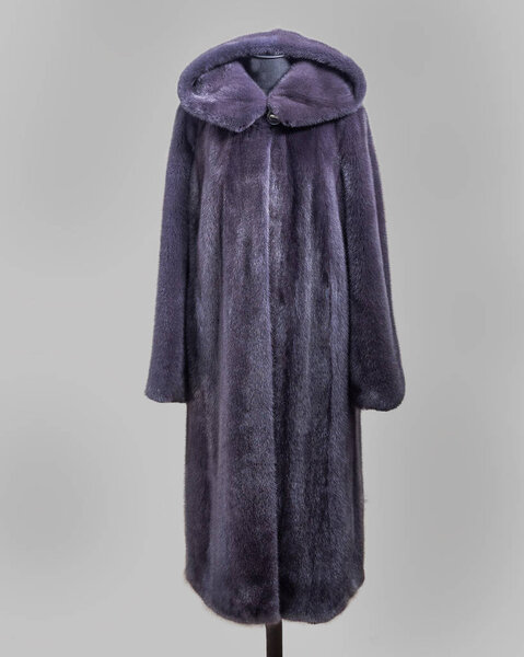 Mink fur coat in purple-gray tones on the construction of the trading floor for the store catalog.