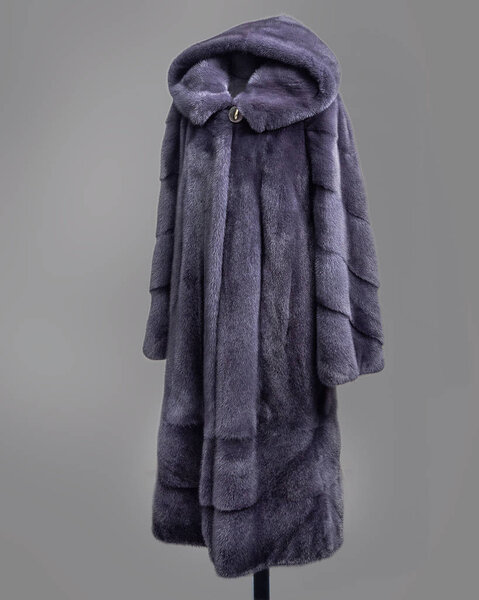 Mink coat gray-lilac with a decorative skirt of transverse strips of fur, side view. Horizontal frame
