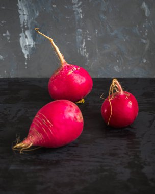 Gri arkaplanda yeni büyük kırmızı turp mahsulü,