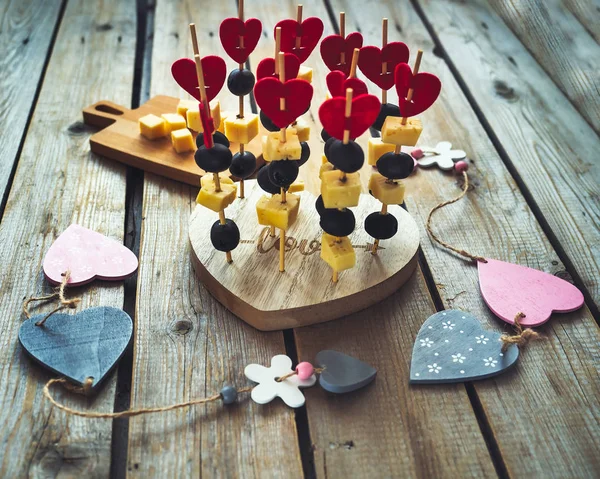 Gâteries pour la Saint-Valentin, nanapes légères sur un stand bouclé en bois . — Photo
