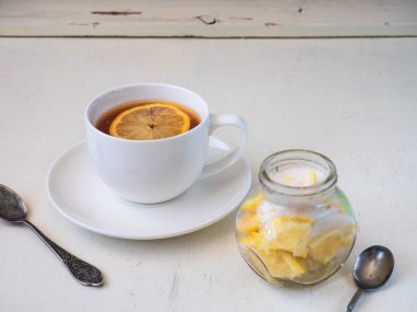 Beyaz seramik bir çiftte limonlu çay partisi çay kaşığı ve dilimlenmiş limon ve serpilmiş cam kavanoz.