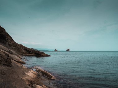 Japon denizinin kayalık kıyıları, ılık bir sonbahar gününde deniz manzarası.