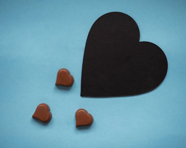 Tarjeta de felicitación con corazones de chocolate y plato negro para escribir texto — Foto de Stock
