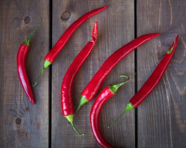 Kırmızı kırmızı kırmızı biber sürüleri ahşap bir masanın üzerinde uzanır.