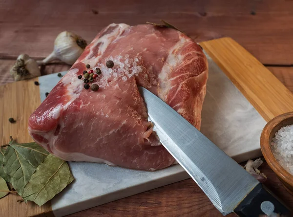 월계수 잎 과 마늘로 돼지고기 광맥을 굽기 위한 준비를 할 때, 커다란 조각이 놓여 있다 — 스톡 사진