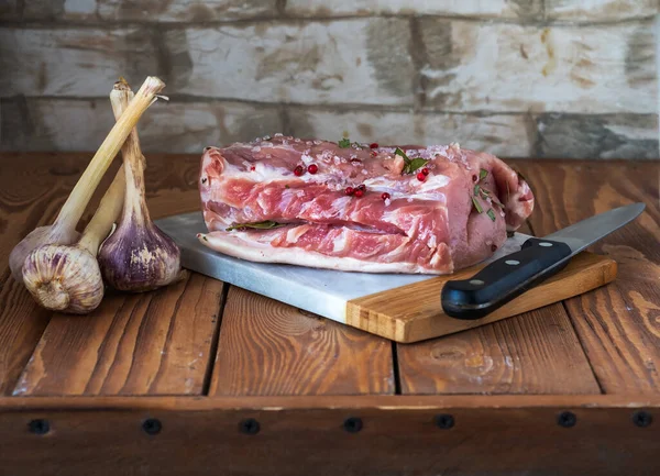 나무 갈색 탁자 위에는 향신료와 어린 마늘을 곁들인 구운 돼지고기 국물이 놓여 있다 — 스톡 사진