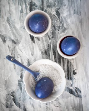 Siyah ve beyaz arka planda üç mor yumurta. Tuz makinesinde tuz ve seramik kaşık. Hızlı protein kahvaltısı. Yukarıdan görüntüle