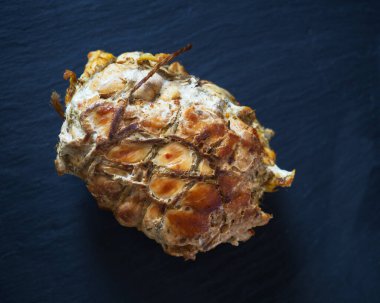 Ev yapımı tavuk budu, sicimle bağlanmış. Şist tabağında servis yap. Yakın plan.