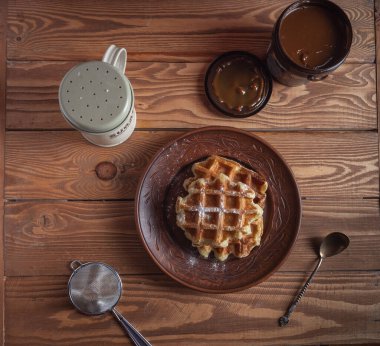 Taze pişmiş ev yapımı waffle, kavanozla kaynatılmış süt.