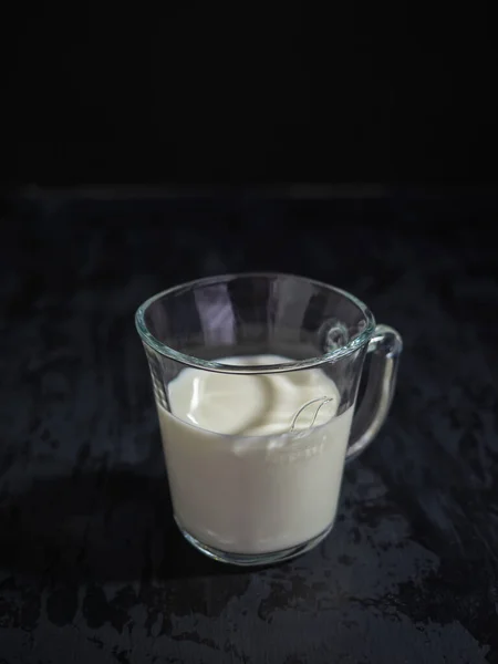 Tazza di vetro di latte su sfondo nero, spazio per il testo — Foto Stock