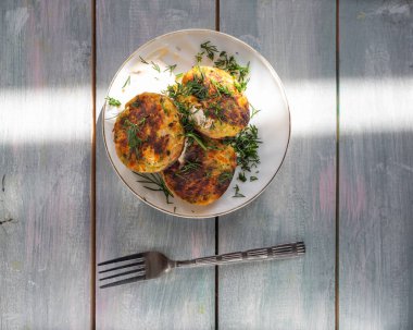 Ev yapımı yemek. Sebzeli pirzola ve çatal. Ahşap bir masa üstünde servis yapmak.