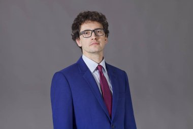 Güzel adam gözlük ve kıvırcık saçlı mavi takım elbise