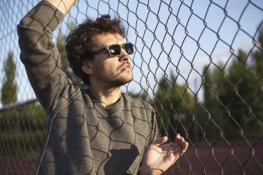 Ayakta ve demir çit tutan genç adam