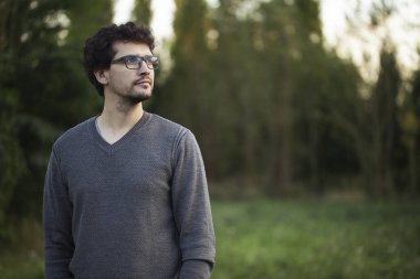 Sakin adam parkta sola bakıyor ayakta