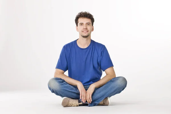 Gömlek ve kot pantolon bacak bacak ile oturan güzel çocuk