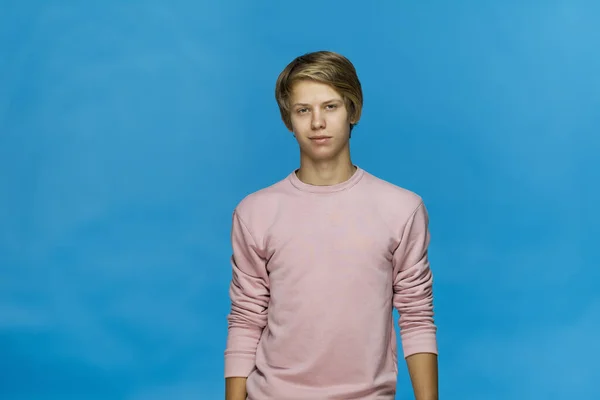 穿着粉红短衫 面带微笑的少年与蓝色背景的摄影相比 孤立无援 — 图库照片