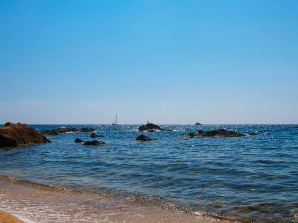 Velero y barco navegando visto desde la playa Imagen De Stock