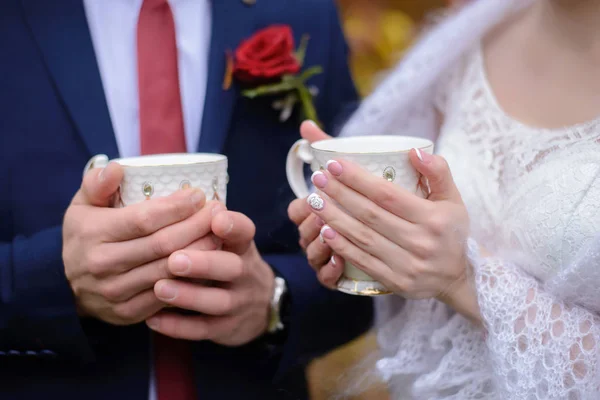 The bride and groom are holding mugs of tea — Stock Photo, Image