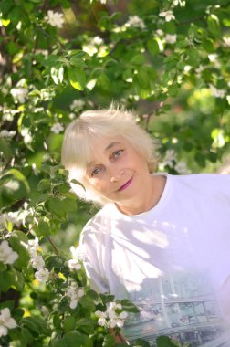 Çiçeklenme tree yakınındaki yaşlı bir kadın