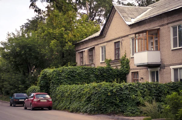 Ein altes zweistöckiges Haus mit grünem Zaun — Stockfoto