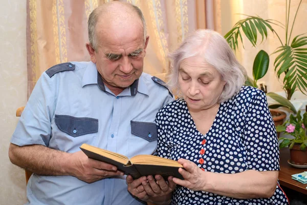 Bejaarde echtpaar lezen van een boek samen thuis — Stockfoto