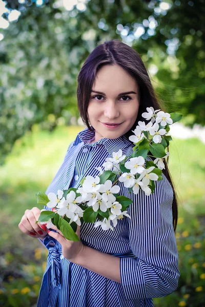 Retrato de una niña con una rama de flores de manzana —  Fotos de Stock