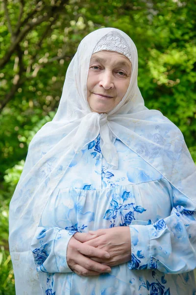 Uma mulher muçulmana idosa em roupas brilhantes — Fotografia de Stock