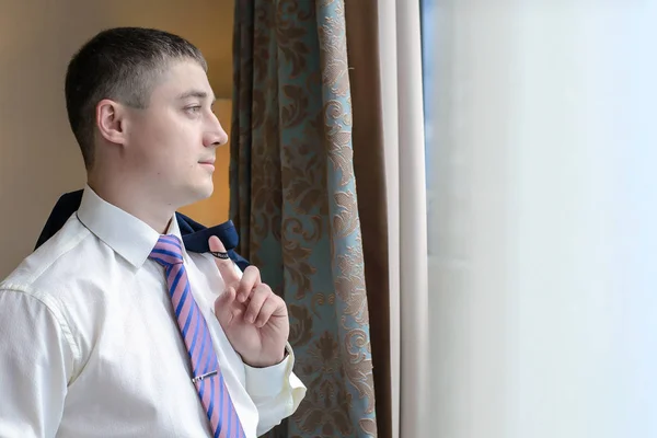 Młody człowiek, stojąc przy oknie — Zdjęcie stockowe