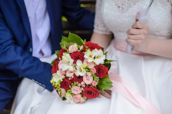 Bröllop bukett i händerna på brud och brudgum — Stockfoto