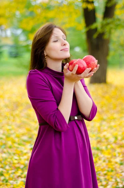 Молодая красивая беременная девушка с яблоками осенью — стоковое фото