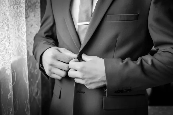 Imagen en blanco y negro: un hombre abrocha su chaqueta —  Fotos de Stock