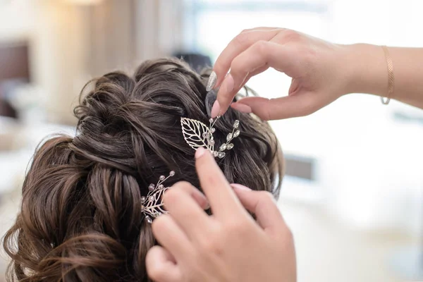 Hairdresser makes the bride hairstyle