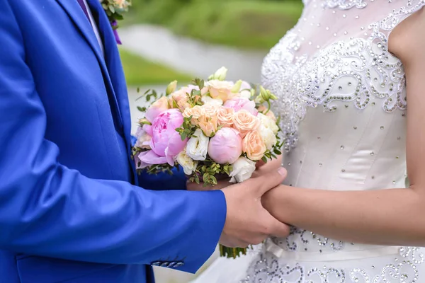 Bröllop bukett i händerna på brud och brudgum — Stockfoto