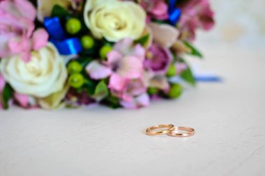 Altın alyans ve beyaz bir masaya gelin buketi