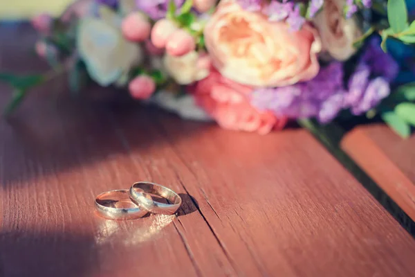 Gold wedding rings on a wooden surface — Stock Photo, Image
