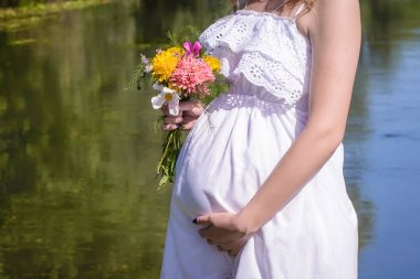 Karnını tutan hamile bir kadın.