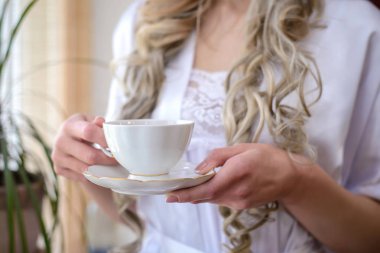 Sabah gelin: bir kız bir fincan çay veya kahve closeup tutuyor