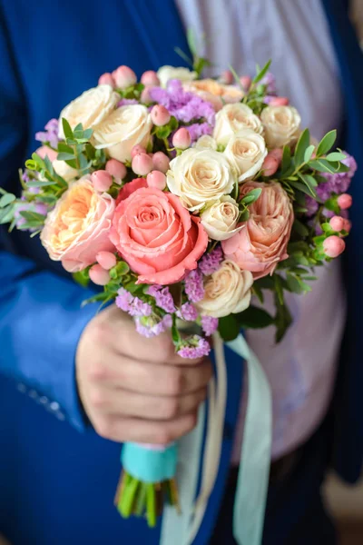 De bruidegom houdt een bruiloft boeket — Stockfoto