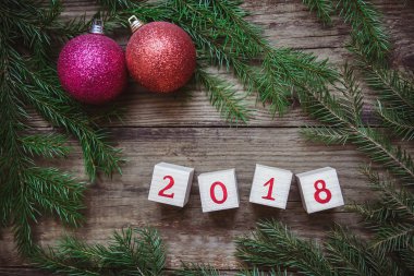 Noel ağacı dalları, blok numarası 2018 ve oyuncak kırmızı topları ile resimle