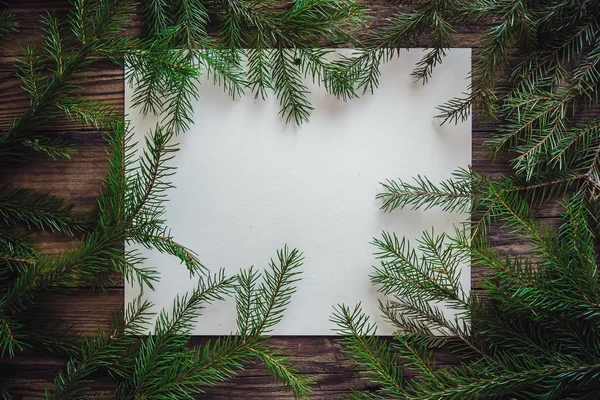 Fondo de madera de Navidad con hoja de papel y ramas de abeto — Foto de Stock