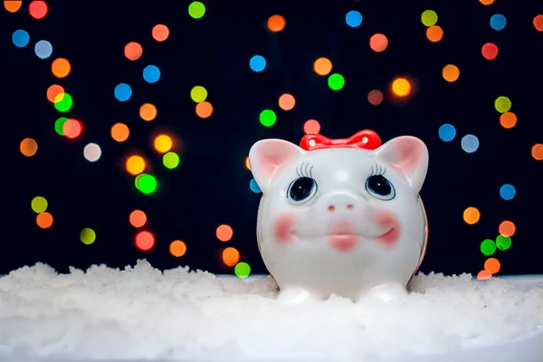 Lustiges Sparschwein auf einem Hintergrund aus farbigen Lichtern zu Weihnachten — Stockfoto