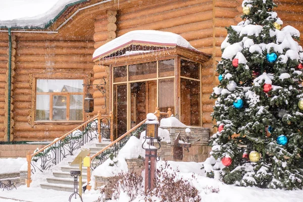 在雪地里的一座木屋的入口处的圣诞树 — 图库照片