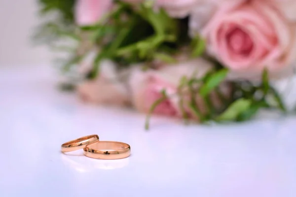 Obrączki na różowym tle z Bukiet ślubny — Zdjęcie stockowe
