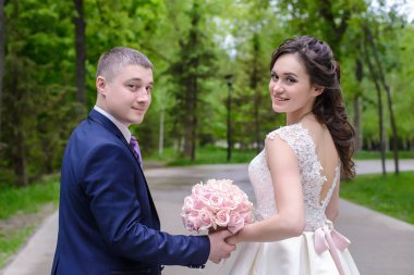 Parkta düğün buketi olan gelin ve damat