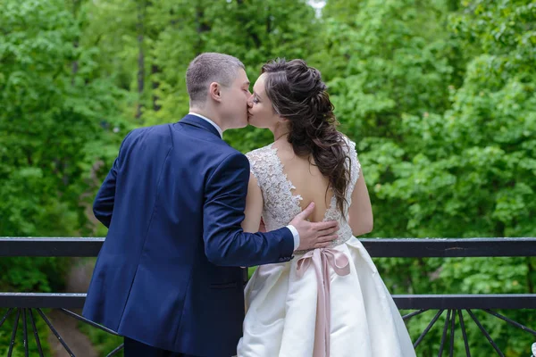 Νύφη και γαμπρός φιλάει στη γέφυρα, την ημέρα του γάμου τους — Φωτογραφία Αρχείου